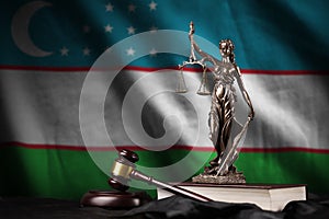 Uzbekistan flag with statue of lady justice, constitution and judge hammer on black drapery. Concept of judgement and