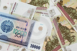 A Uzbekistan som bank note with Russian one hundred ruble bank notes