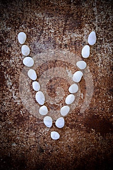 'V' alphabet made form white stone
