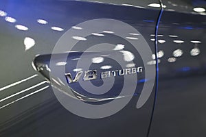 V8 biturbo sign of a Mercedes Benz C 63s AMG coupe 2017. Front Headlight .Car exterior details.