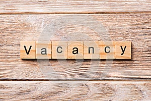 Vacancy word written on wood block. Vacancy text on wooden table for your desing, concept