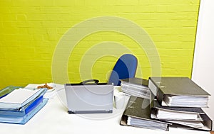 Vacant desk with laptop, folders and empty chair