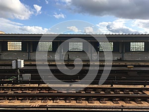 Vacant subway platform and train track, above ground subway station in NYC