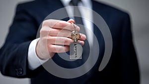 Vacant word on keychain in businessman hand, available room in hotel, closeup