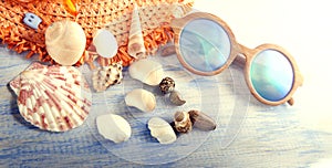 Vacation beach accessories glasses hat cockleshells on wood back