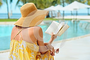 Vacation Beach Summer Holiday Concept. Beautiful woman in yellow dress reading book resting in beach