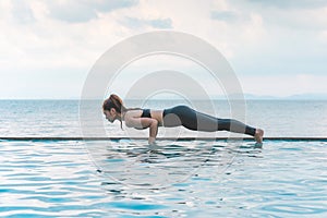 Vacation of Beautiful Attractive Asian young woman practice yoga Plank or Phalakasana Pose on the beach