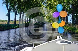 Vacation boat with balloons in Canal du Midi, family travel river cruise by barge penichette, holidays in France