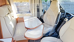 Vacation campervan with luxury white interior table wooden and seat in modern motor home during vanlife concept