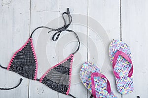 vacation concept - fashion swimsuit with flip flops in polka dots on white wooden table