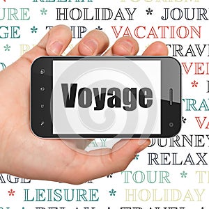 Vacation concept: Hand Holding Smartphone with Voyage on display