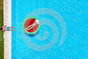 Vacation concept with a happy couple on a watermelon shaped float having fun