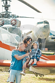 Vacation concept. Happy family enjoy summer vacation at military air show. Child with mother and father sit on plane