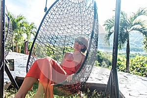 Vacation concept. Young woman swing on tropical island Nusa Lembongan, Bali, Indonesia.
