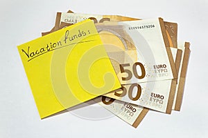 Vacation funds. having the money. stack of 50 euros yellow sticky note