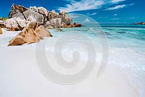 Vacation holiday. Ocean waves and granite rocks, perfect white sand, turquoise water and blue sky. Anse Cocos beach at Seychelles
