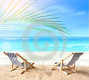 Vacation holidays background concept - two beach lounge chairs under palm on summer beach.