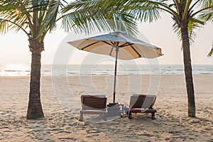 Vacation holidays background of two lounge chairs under tent on beach