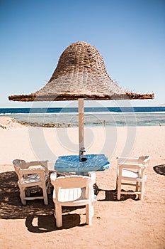 Vacation holidays. three beach lounge chairs under tent on beach.