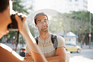 Vacation memories. a young man posing for a photo while touring a foreign city.