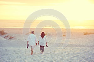 Vacation mode on. a mature couple going for a relaxing walk on the beach.