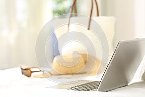 Vacation objects and laptop on an bed in an hotel room