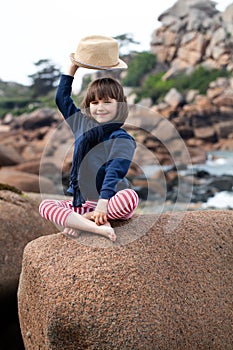 Vacation postcard concept with smiling child raising hat for hello