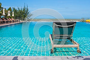 Vacation and Relaxation Concept : Daybed beside swimming pool in the resort.