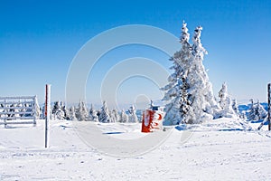 Vacation rural winter background with white pine, fence, snow field, mountains