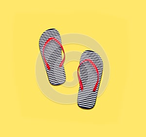 Vacation season - the concept. Beach flip flops on a yellow background.