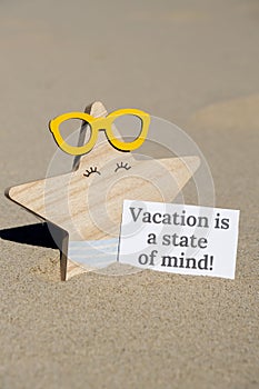 VACATION IS A STATE OF MIND text on paper greeting card on background of funny starfish in glasses summer vacation decor