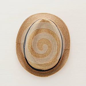 vacation and summer image with fedora beach hat over white wooden background.