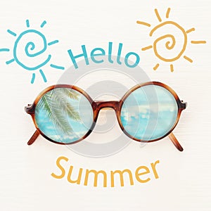 vacation and summer image with sunglasse over white wooden background. photo