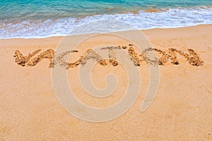 Vacation text on a beach. Vacation written in a sandy tropical beach. \