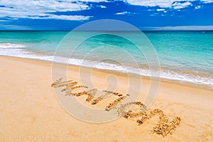 Vacation text on a beach. Vacation written in a sandy tropical beach. \