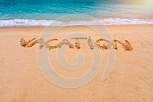 Vacation text on a beach. Vacation written in a sandy tropical beach. \