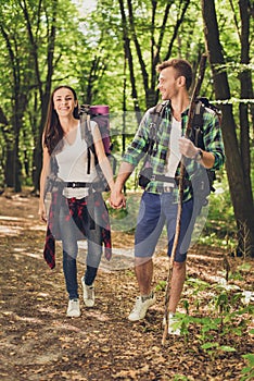 Vacation together. Happy young couple hiking in the woods, holdings hands, smiling, posing for a family portrait for memories, goo