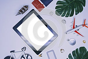 Vacation and travel concept on the theme of tourism. Mockup of a tablet with a white screen with an airplane, a ship and a bicycle