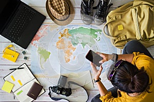 Vacation travel planning concept with map. Overhead view of equipment for travelers. Travel concept background, young Asian woman