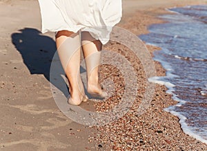 vacation travel - woman leg closeup walking on white sand relaxing