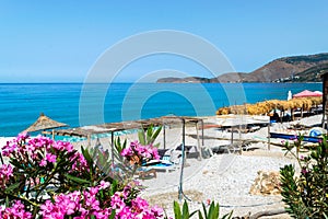 Vacationers on long Borsh beach with clear blue water. Cloudless sky. Albania. Ionian Sea