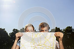 Vacationing Couple Looking At Large Map