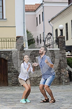 Vacations Travel Ideas. Happy Caucasian Couple Having Fun While Preparing To Jump Together During Traveling in The City