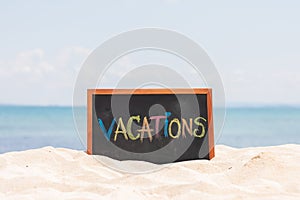 Vacations word in Blackboard on paradise tropical island beach with blue sky in summer for relaxation and vacations in Thailand