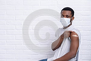 vaccinated African American man showing arm with medical plaster patch Plaster On Shoulder, black female after getting