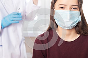 Vaccination of adolescents in medical clinics, schools, a doctor giving an injection to a girl in a hospital, a nurse holding a