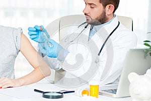 Vaccination. Flu shot. Doctor injecting flu vaccine to patient`s arm