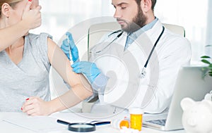 Vaccination. Flu shot. Doctor injecting flu vaccine to patient`s arm