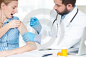 Vaccination. Flu shot. Doctor injecting flu vaccine to patient`s arm