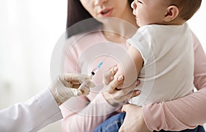 Doctor giving intramuscular injection to little baby